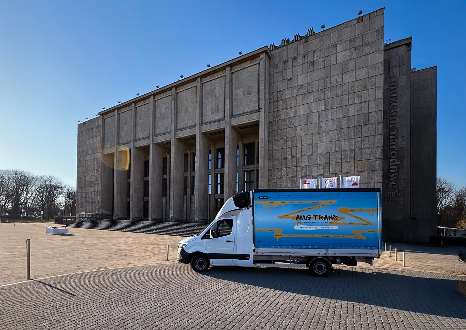 Bus AMG Trans zaparkowany przed budynkiem w Europie – wizualizacja transportu kabotażowego