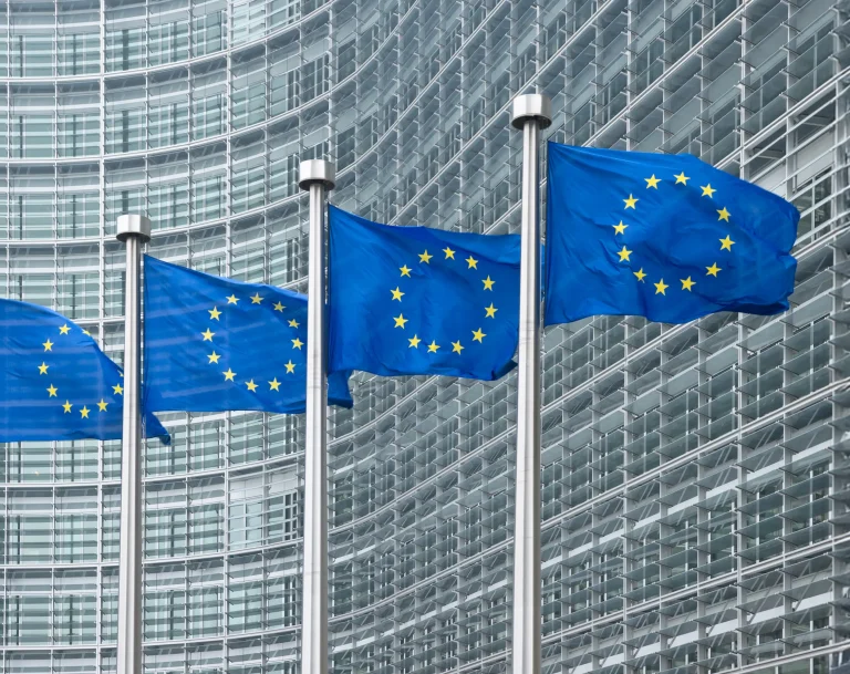 Flagi Unii Europejskiej przed siedzibą Komisji Europejskiej w Brukseli – symbol regulacji transportowych i przepisów kabotażu w UE.