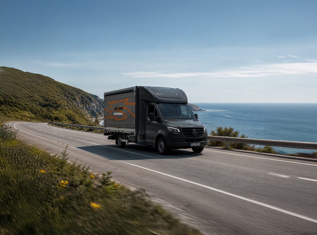 Samochód dostawczy AMG Trans na trasie nad morzem – transport ekspresowy w Europie